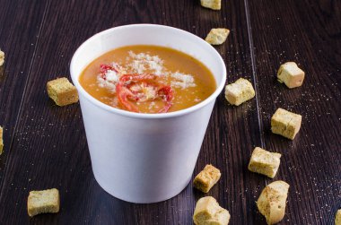 Parmesanlı rendelenmiş domates kremi ve koyu ahşap arka planda kızarmış ekmek.