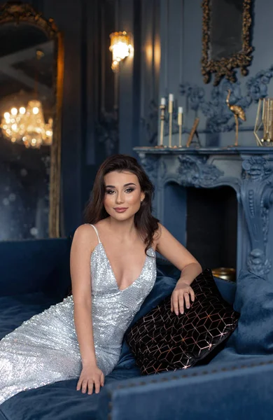 Koyu yakalı gümüş elbiseli şık, romantik bir esmer.