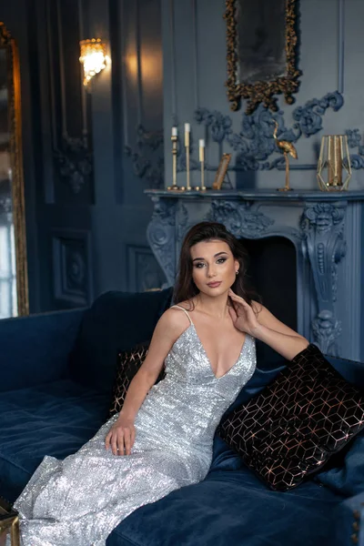 Schöne sexy Brünette im silbernen Kleid mit tiefem Ausschnitt posiert — Stockfoto