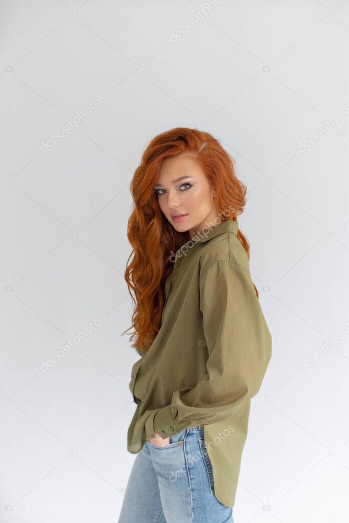 Beautiful redhead girl in a khaki shirt and jean