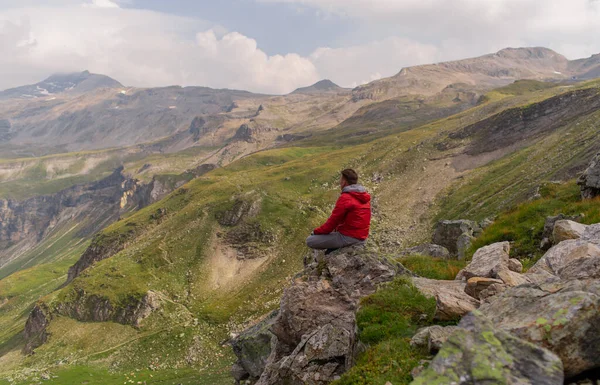 Fiatalember Piros Kabátban Köveken Bámulatos Kilátás Nyílik Alpok Hegyre — Stock Fotó