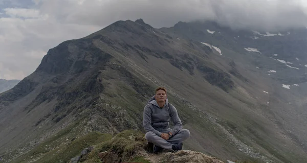 Fiatalember Alpok Tetején Meditál — Stock Fotó