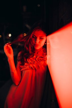 Yazlık elbiseli genç bir kız gece şehirde dolaşıyor.