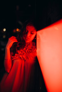 Yazlık elbiseli genç bir kız gece şehirde dolaşıyor.