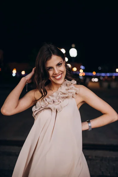 Yazlık elbiseli genç bir kız gece şehirde dolaşıyor.