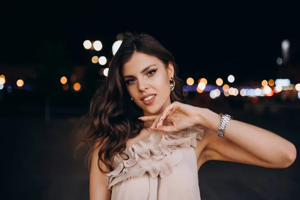 Yazlık elbiseli genç bir kız gece şehirde dolaşıyor.