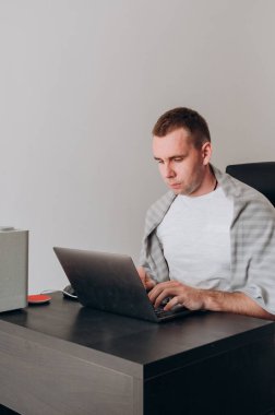 Genç bir adam karantinadaki bir bilgisayarda çalışıyor.