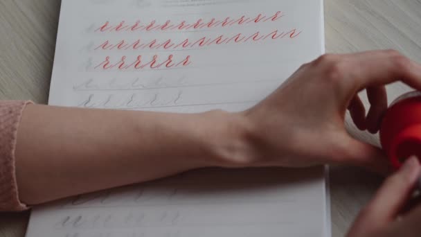 Ein Mädchen Füllt Ein Kalligraphie Notizbuch Mit Schönen Symbolen — Stockvideo