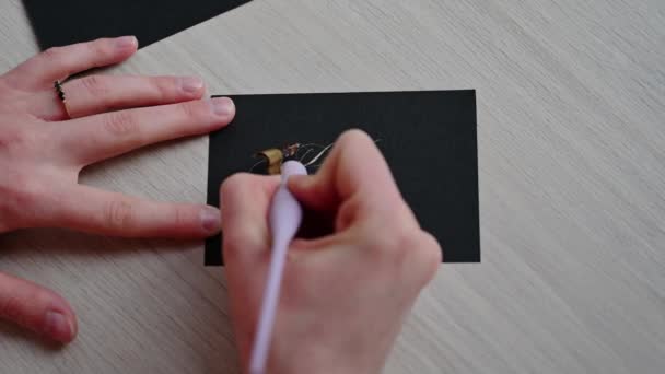 这个女孩用钢笔在黑纸上写了一个笔迹优美的字 — 图库视频影像