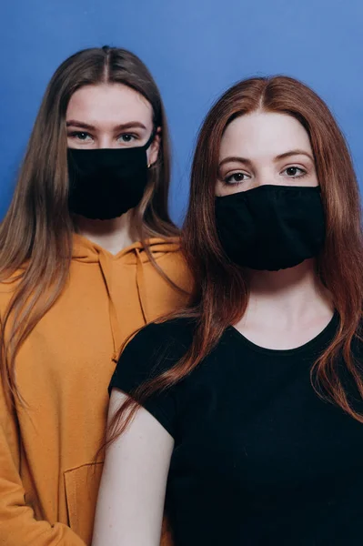 Mavi arka planda antiviral maskeli güzel bir kız.