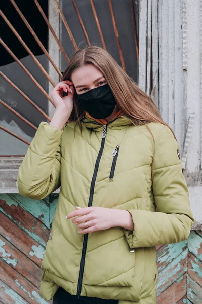 Antivirüs maskeli genç bir kız sokakta yürüyor.