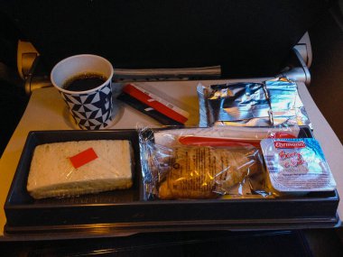 Ekonomi sınıfında katlanan bir masanın üzerinde, kutuda bir yemek takımı. Moskova 'dan gelen bir uçakta Rus yemeklerini beslemek. - Rusya. Görünüm.