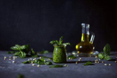 Ev yapımı pesto sosu, fesleğen, gri arka planda zeytinyağı.