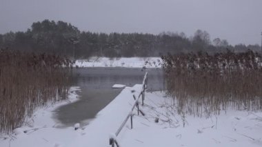 çözülmüş nehir kışın akar. Banyo iskelesi köprüsü Kar, orman ve buzlar