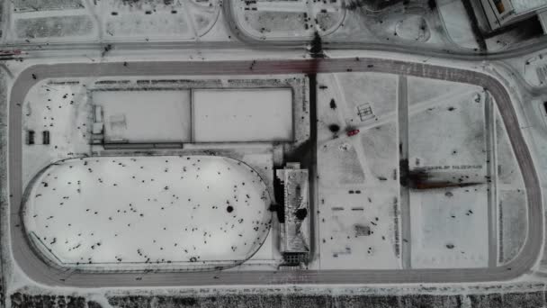 La gente está patinando día de pista de hielo. alrededor está la cinta de correr. Vista aérea de arriba hacia abajo . — Vídeos de Stock