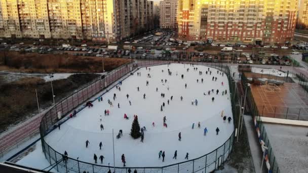 Mucha gente patinando en la ciudad en la pista de hielo con árbol de Navidad — Vídeos de Stock