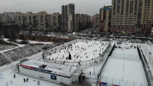 Mucha gente patinando en la ciudad en la pista de hielo con árbol de Navidad — Vídeos de Stock