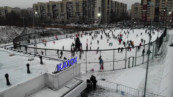 Mucha gente patinando en la ciudad en la pista de hielo con árbol de Navidad — Vídeos de Stock