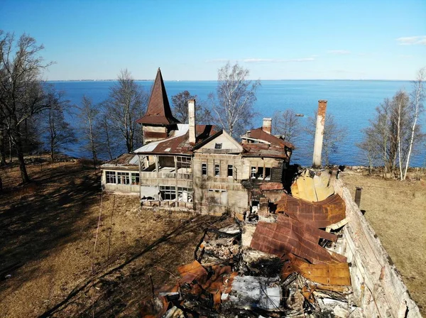 Opuszczony zrujnowany dom z wieżą i kominami na wybrzeżu — Zdjęcie stockowe