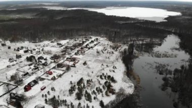 Ormandaki köy, kışın ahşap köprüsü olan geniş nehrin yanında.
