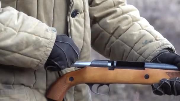El hombre que lleva un arma de fuego inserta munición en una escopeta aserrada con un sonido — Vídeo de stock