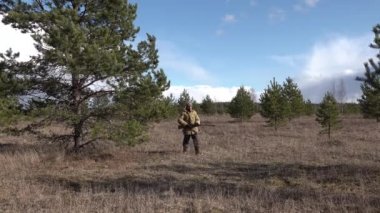 İnsan avcısı Kızıl Ordu orman tarlasına gidiyor ve av tüfeğini ateşliyor.