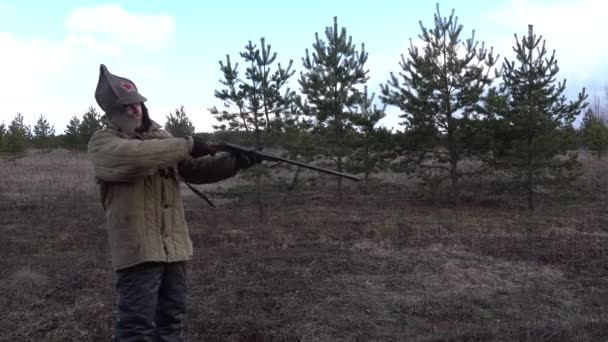 Man hunter soldier Red Army the forest field shoots firing shotgun, double gun — Stock Video