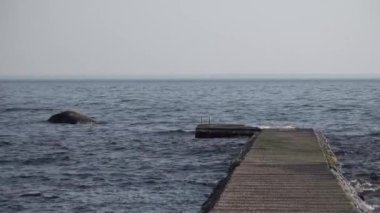 Denizde ya da gölde ahşap iskele. Sakin ve küçük dalgalar.