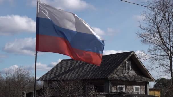 Bandera rusa en pueblo ruso se desarrolla en el viento unido a una caña de pescar — Vídeo de stock