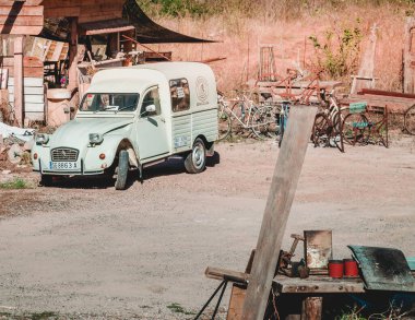 Hurda metal dolu bir bahçede eski bir araba.