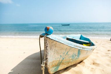 Okyanus arka planda sahilde bizi bekleyen bir tekne üzerinde Mini dünya