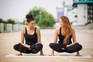 Açık havada bir kentsel neighbourhoo Yoga yapıyor iki güzel kadın