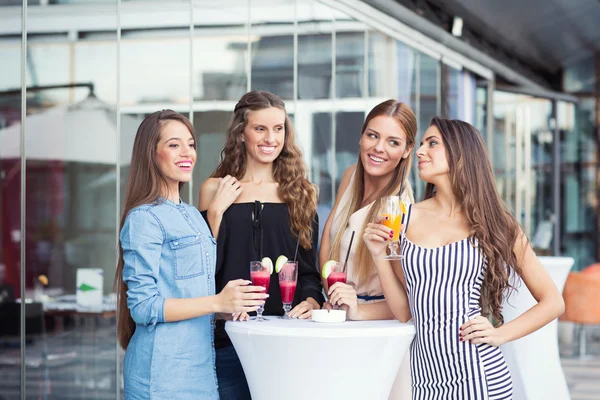 Four girlfriends having drinks outdoors — Stock Photo, Image