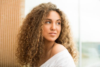 Kıvırcık saçlı güzel bir kızın portresi.