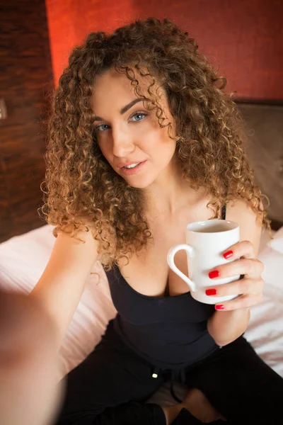 Menina bonita com cabelo encaracolado tomando selfie — Fotografia de Stock