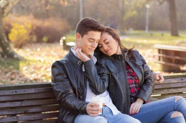 Parktaki bankta oturan mutlu genç çift