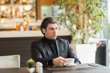 yakışıklı genç adam kahve içiyor.