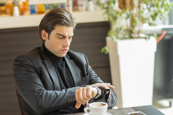 Joven guapo mirando su reloj — Foto de Stock