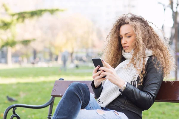 Al aire libre, mujer joven con teléfono inteligente —  Fotos de Stock
