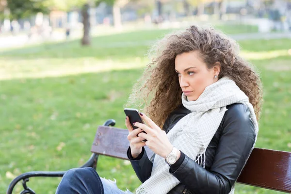 На улице, молодая женщина со смартфоном — стоковое фото
