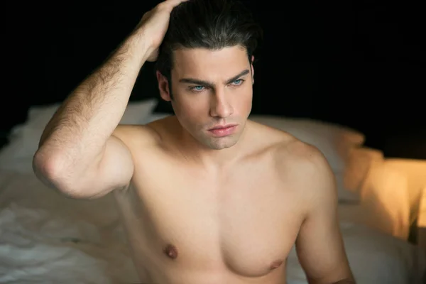 Portret van een shirtless man in bed — Stockfoto
