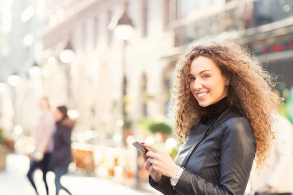 Al aire libre, mujer joven con teléfono inteligente — Foto de Stock
