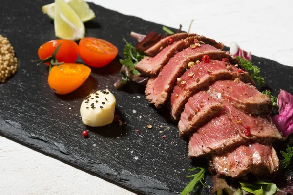 Steak de bœuf grillé rare tranché avec des légumes — Photo