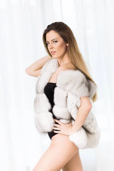 Beautiful woman in luxury fur coat indoor — Stock Photo, Image