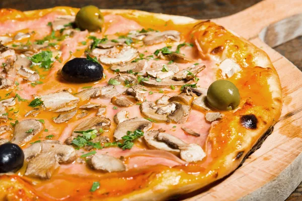 Pizza z szynką, pieczarkami i oliwkami — Zdjęcie stockowe