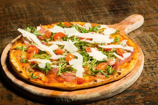 Pizza med skinka, tomater, parmesan och ruccola — Stockfoto