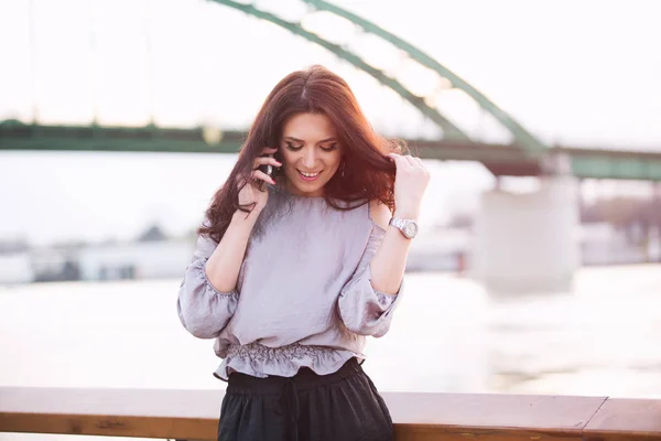 Mooie vrouw stond aan de rivier met mobiele telefoon — Stockfoto