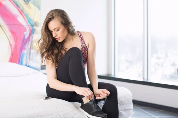 Mooie fitness meisje indoor, op bed — Stockfoto