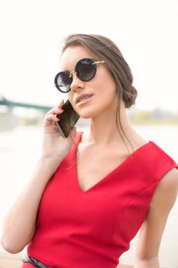 Açık havada, mobile ile Kırmızı elbiseli güzel kadın