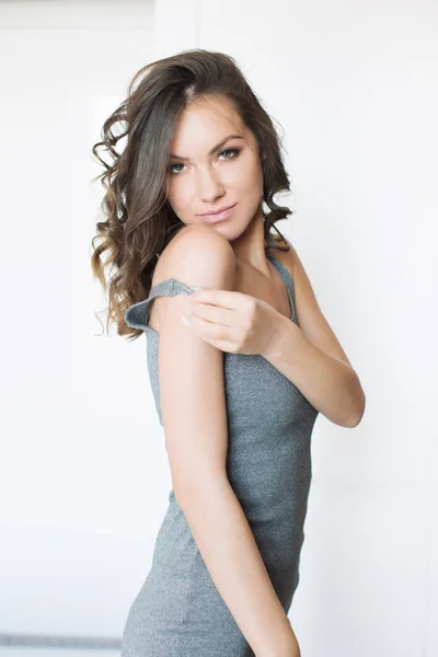 Beautiful young woman in gray dress — Stock Photo, Image